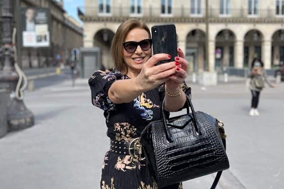 Momento influencer de moda: Valeria Doustaly com celular em Paris