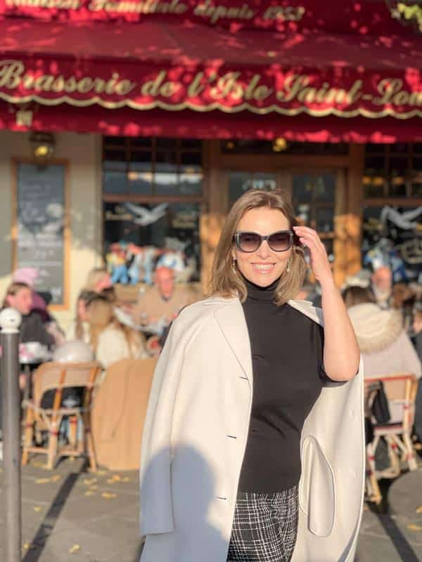 Valeria Doustaly na frente de restaurante parisiense