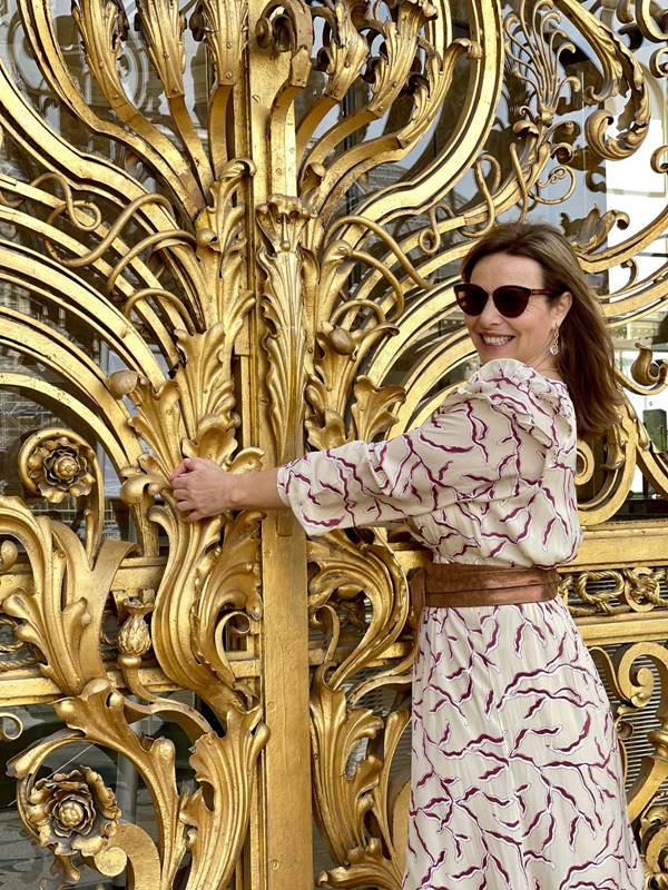 Valeria Doustaly tirando fotos em porta dourada do Mini Palais